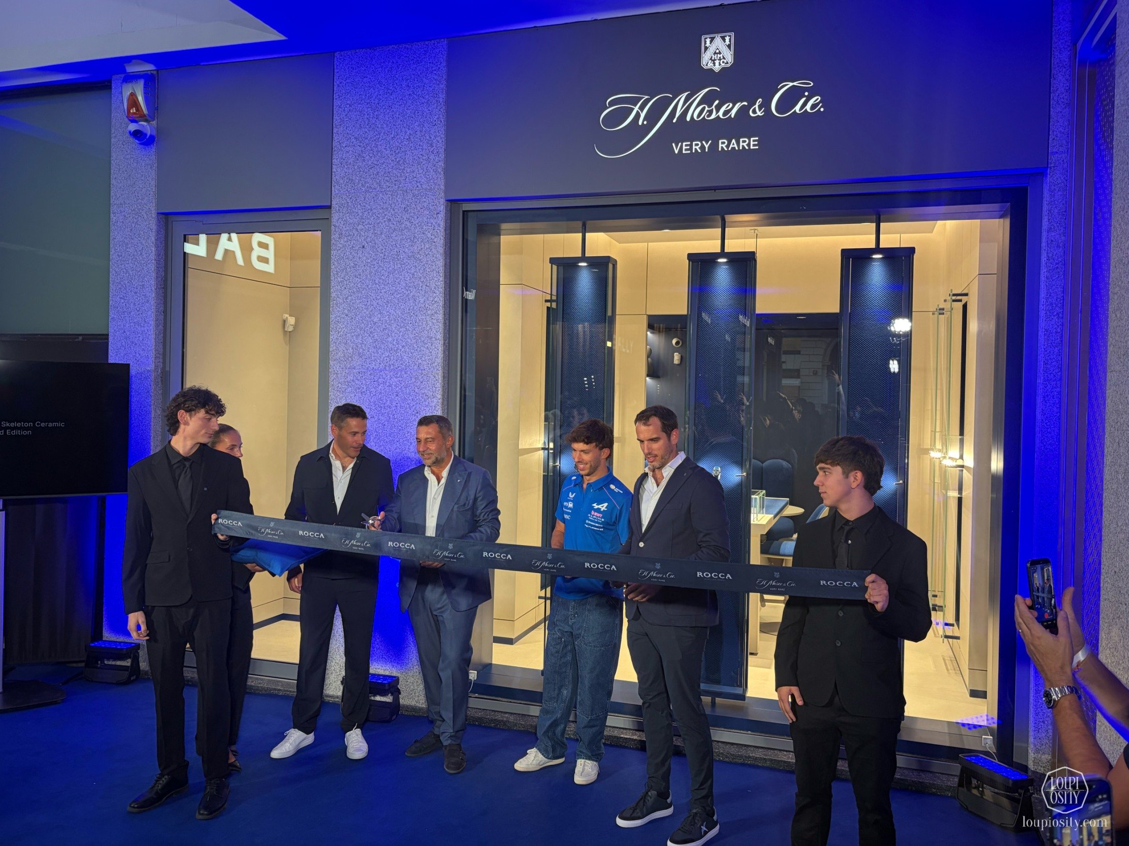 The ribbon cutting at the H.Moser & Cie boutique opening in Milan. From the left: Nicholas Hofmann (International Sales Director, H.Moser & Cie), Giorgio Damiani (Vice President of the Damiani Group), Pierre Gasly (Alpine F1 Team driver), Bertrand Meylan (‏CEO, MELB Luxe Subsidiaries)